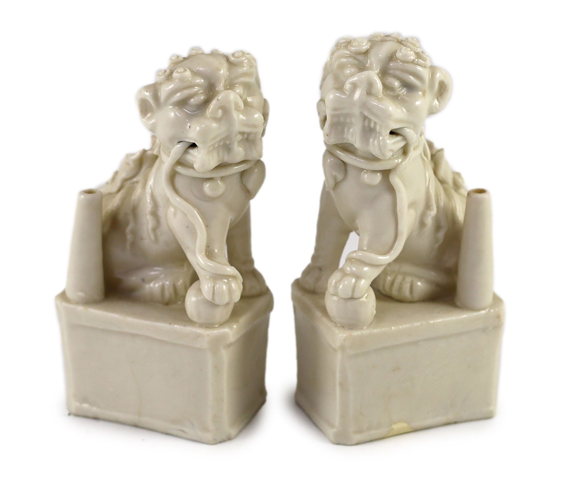 A pair of Chinese blanc-de-chine Buddhist lion joss stick holders, Dehua kilns, Kangxi period, 12.5 cm high, both damaged